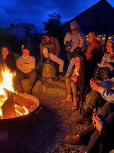Group of people gathering around a fire at night
