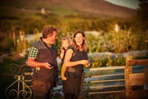 Family smiling in the sun on a farm.